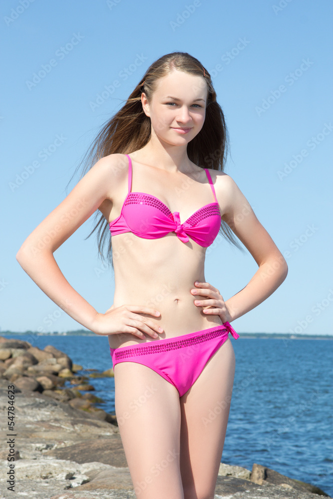 portrait of beautiful woman in pink on rocky beach portrait of beautiful woman in pink on rocky beach