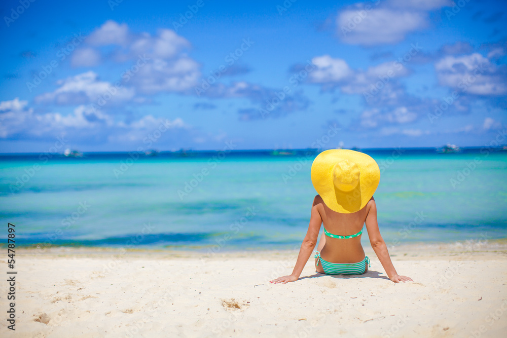 Beautiful back side of model in bikini and hat sitting down. Beautiful back side of model in bikini and hat sitting down.