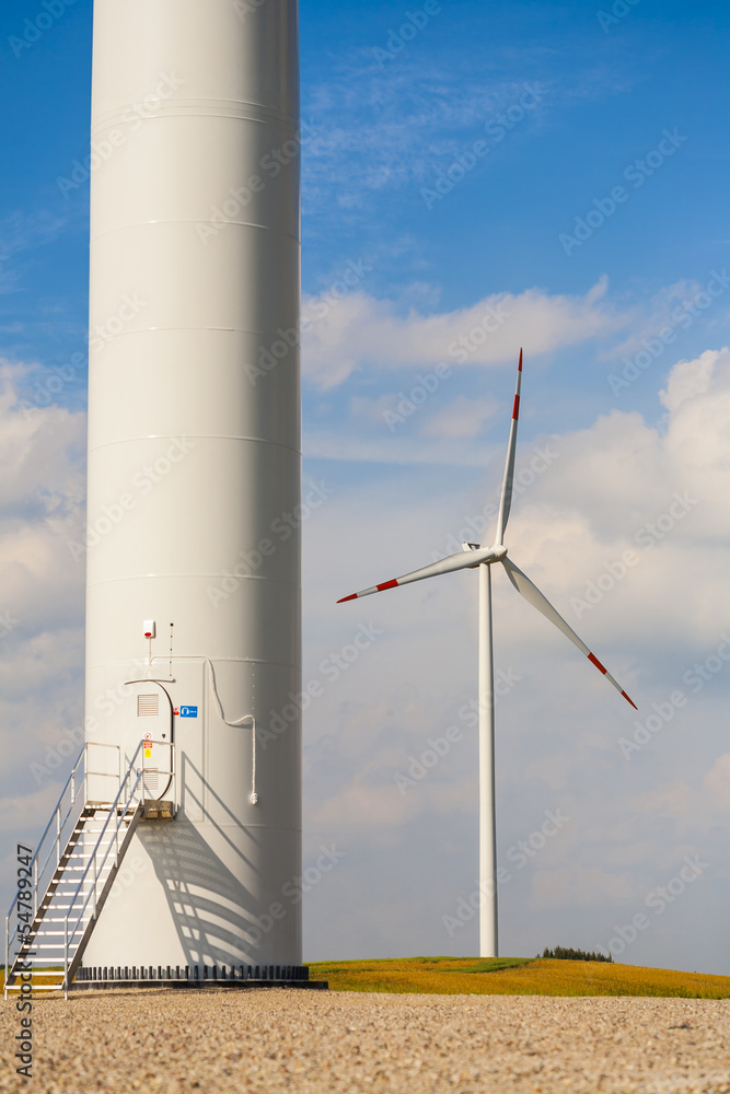 The base of the wind turbine, wind turbine in background. The base of the wind turbine, wind turbine in background.