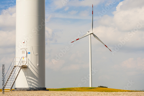 The base of the wind turbine, wind turbine in background.