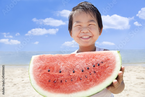 夏の海でスイカを持つ笑顔の子供