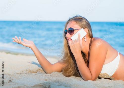 woman on the beach talking on the phone
