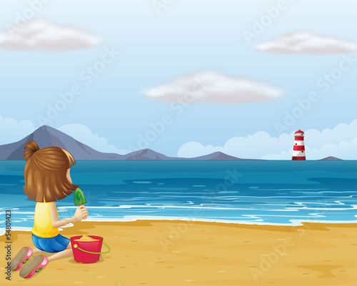 A young girl playing with the sand in the beach