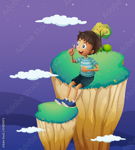 A boy sitting above the high rock formation