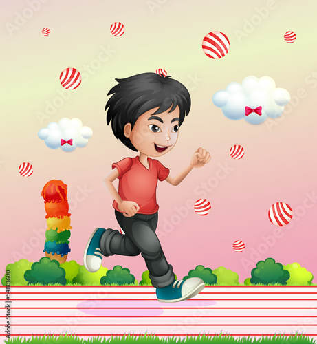 A boy running outside with candy balls