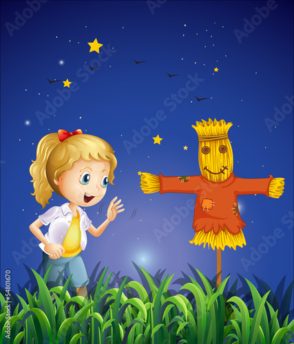 A young girl beside the scarecrow