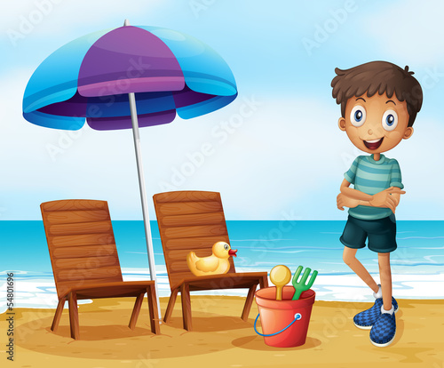 A young boy at the beach near the wooden chairs