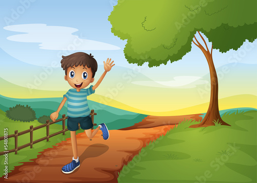 A young boy waving his hand while running