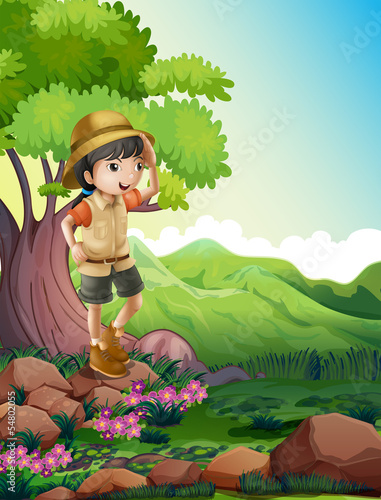 A girl standing above the rock near the giant tree