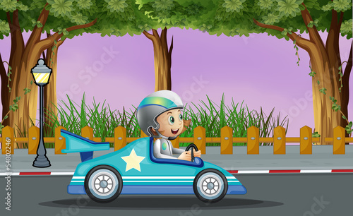 A boy in his blue racing car with a white star