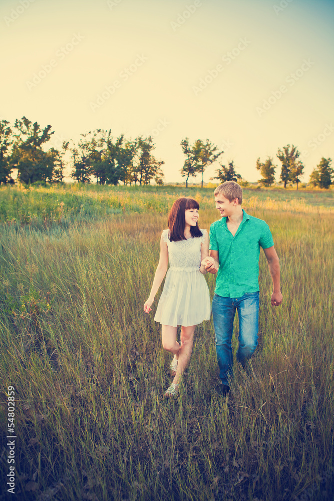 happy young couple walking on a path in the woods