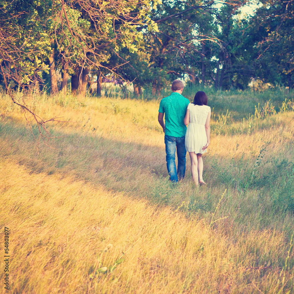 happy young couple walking on a path in the woods