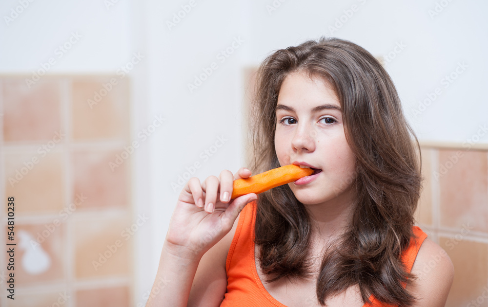 Beautiful teenage girl biting from a carrot Beautiful teenage girl biting from a carrot