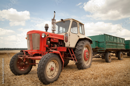 old tractor in field, against a cloudy sky