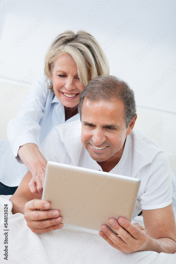 Happy Mature Couple Looking At Digital Tablet