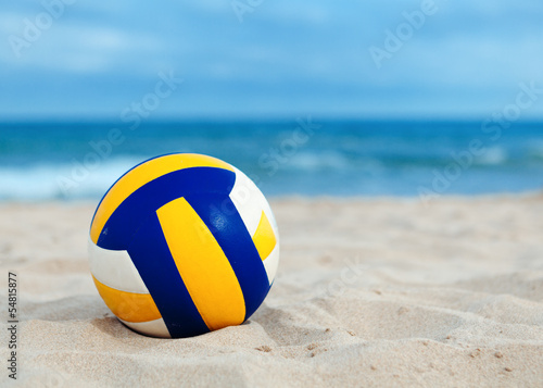 ball is lying on sand near sea