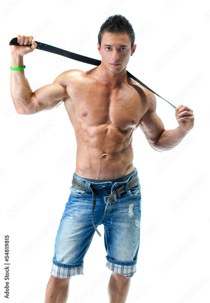 Handsome young bodybuilder in jeans, shirtless with belt Handsome young bodybuilder in jeans, shirtless with belt