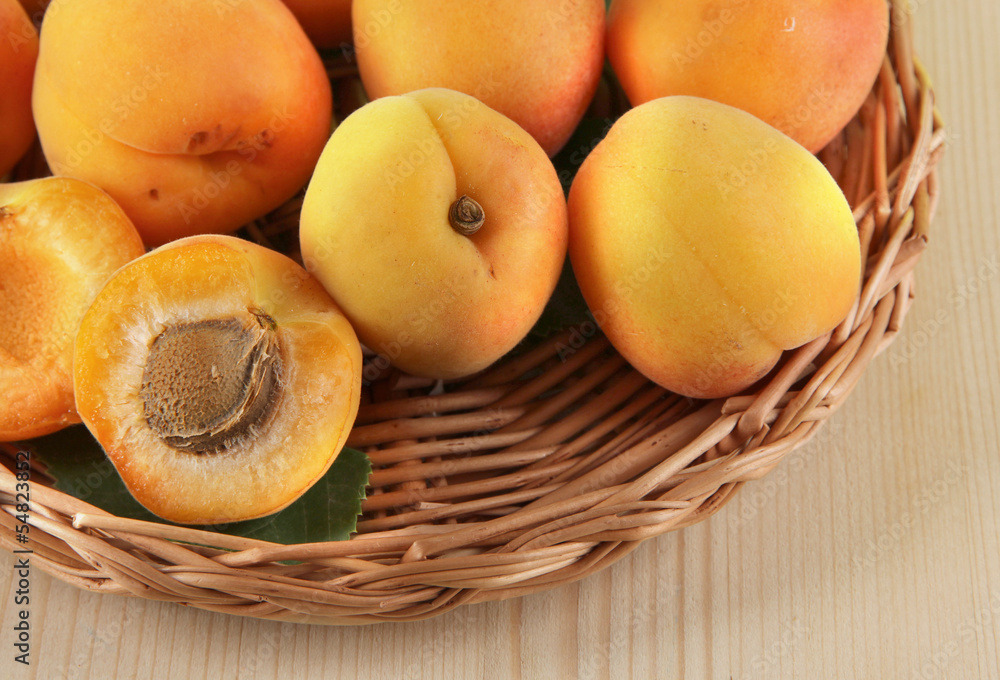 Apricots on wicker coasters on wooden table