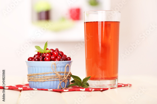 Glass of cranberry juice and ripe red cranberries in bowl