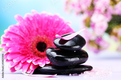 Spa stones and beautiful gerbera on wooden table