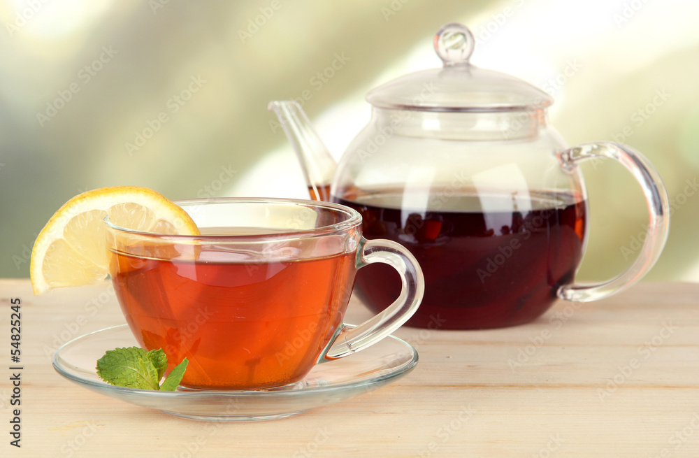 Cup of tea with lemon on table on light background Cup of tea with lemon on table on light background