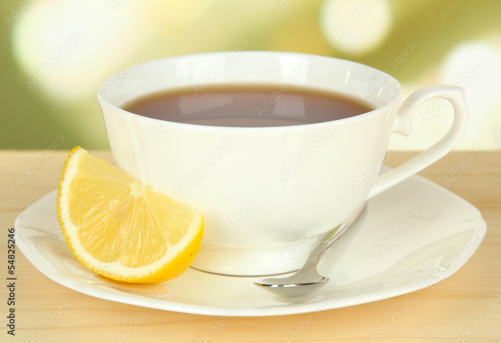 Cup of tea with lemon on table on light background Cup of tea with lemon on table on light background
