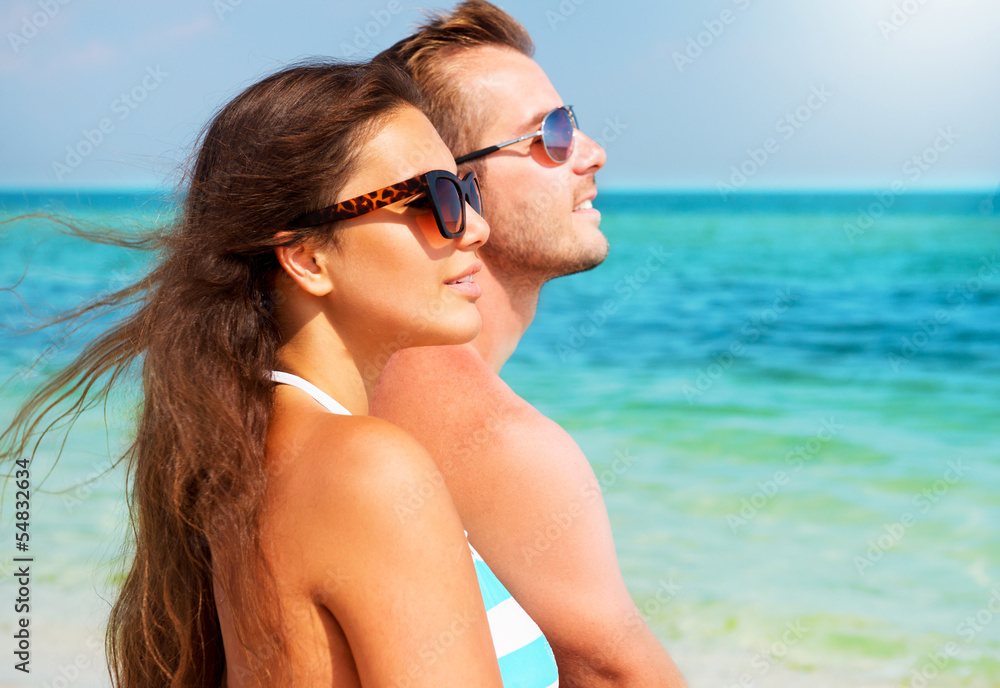 Happy Couple in Sunglasses on the Beach. Summer Vacation Happy Couple in Sunglasses on the Beach. Summer Vacation