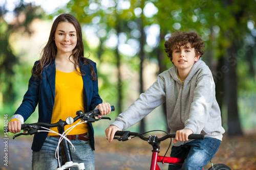 Urban biking - teens riding bikes in city park