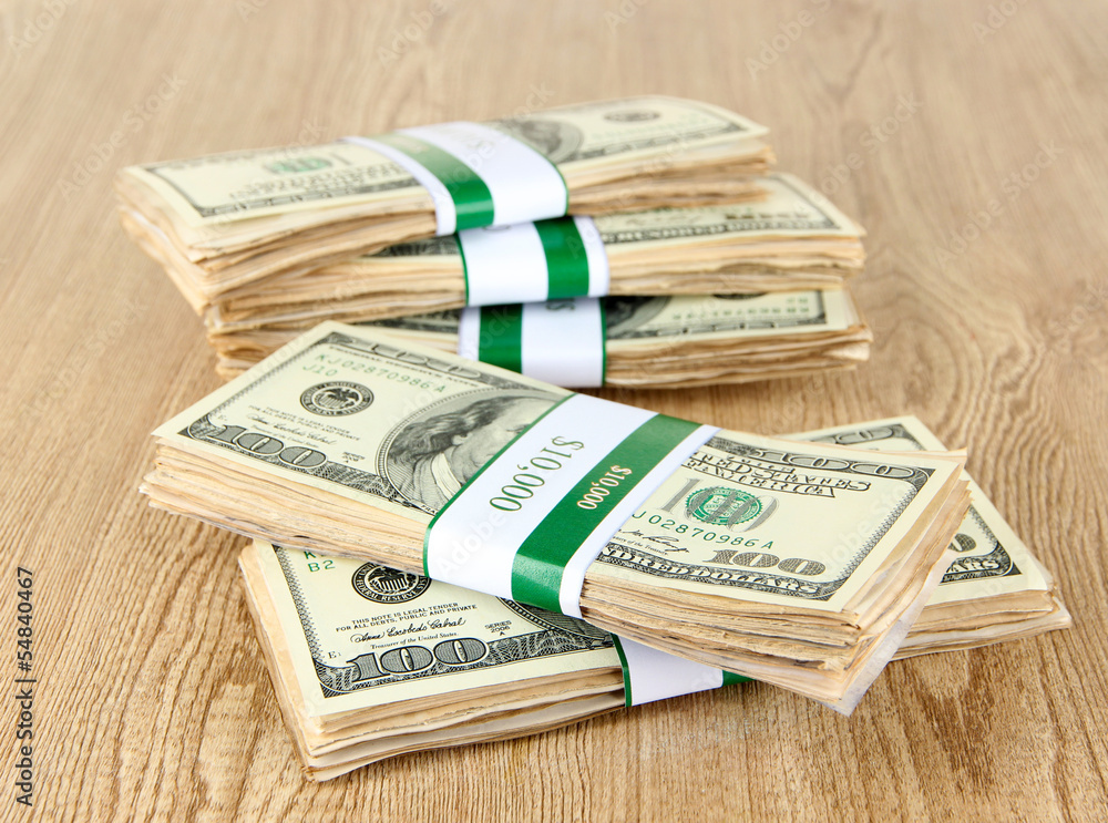 Stacks of money on wooden table Stacks of money on wooden table