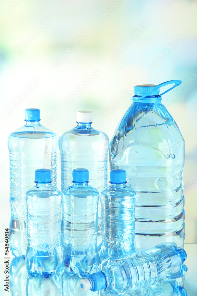 Water in different bottles on light background Water in different bottles on light background