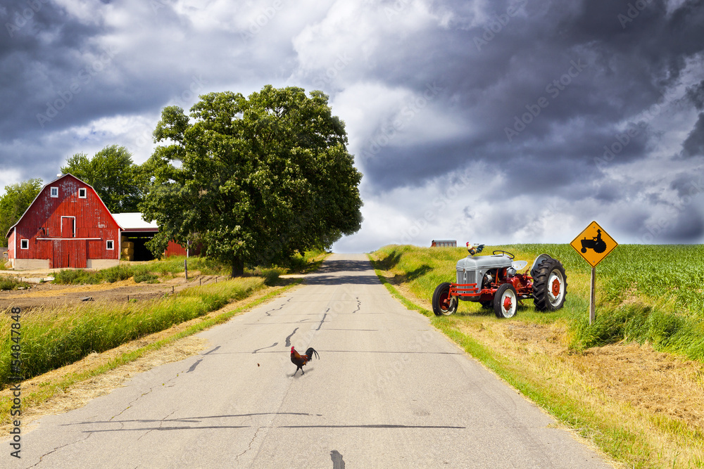 Naklejka premium Country Road With Red Barn and Tractor On Side