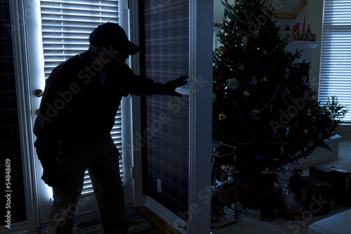 Burglar Breaking In To Home At Christmas Through Back Door
