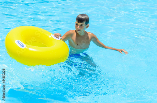 A boy with a rubber ring in the pool