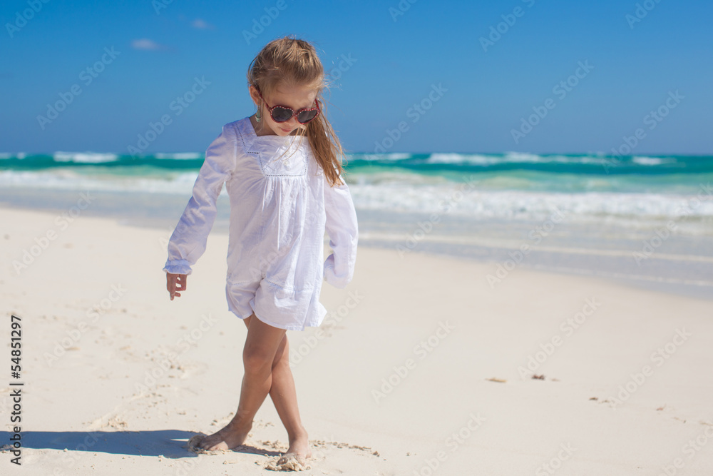 Adorable little girl in beautiful clothes dancing at tropical