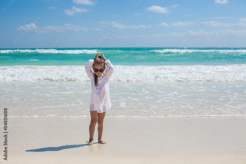 Adorable toddler girl in white dress walking at exotic beach Adorable toddler girl in white dress walking at exotic beach