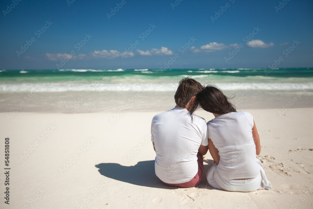 Back view of young couple at tropical white beach Back view of young couple at tropical white beach