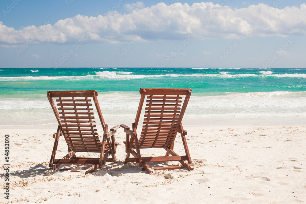 Beach wooden chairs for vacations on tropical beach in Tulum,