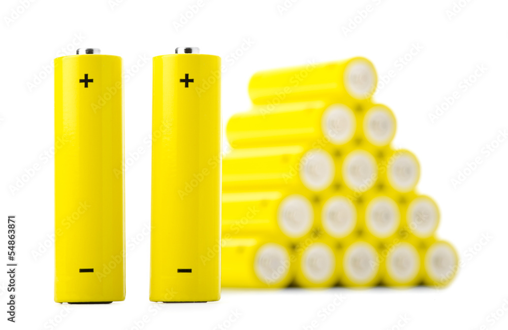 Two batteries in front of stack of batteries Two batteries in front of stack of batteries