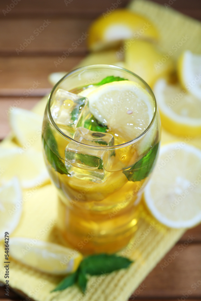 Iced tea with lemon and mint on wooden table Iced tea with lemon and mint on wooden table