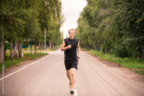Sportive young man jogging outdoor © len44ik