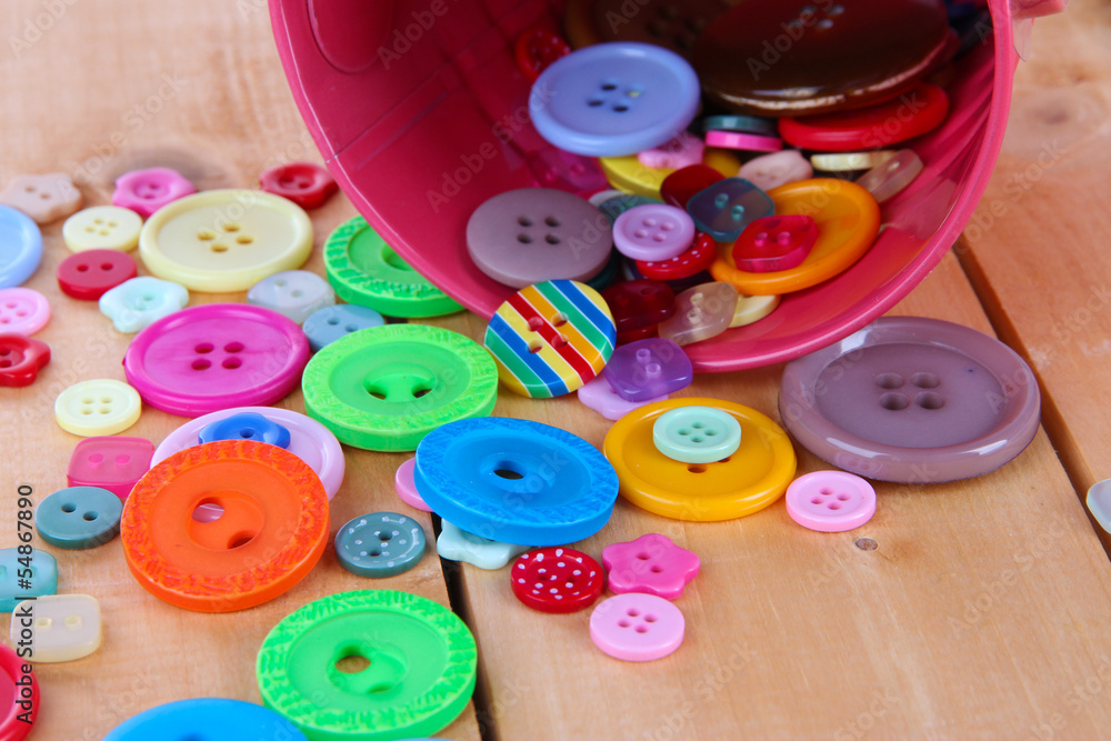 Colorful buttons strewn from bucket close-up Colorful buttons strewn from bucket close-up