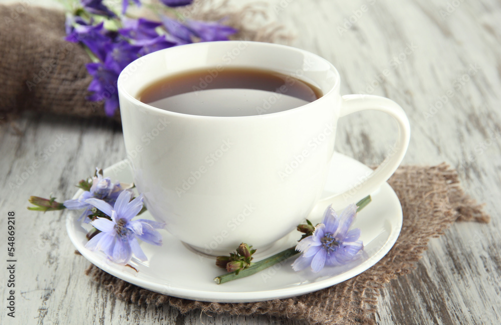 Cup of tea with chicory, on wooden background Cup of tea with chicory, on wooden background