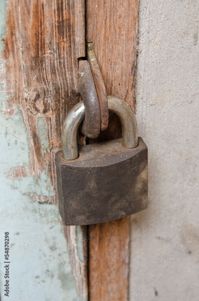 Metal rusty padlock on the old wooden door