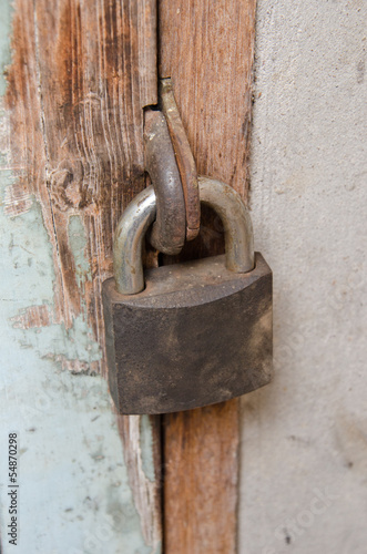 Metal rusty padlock on the old wooden door © erburenustudio
