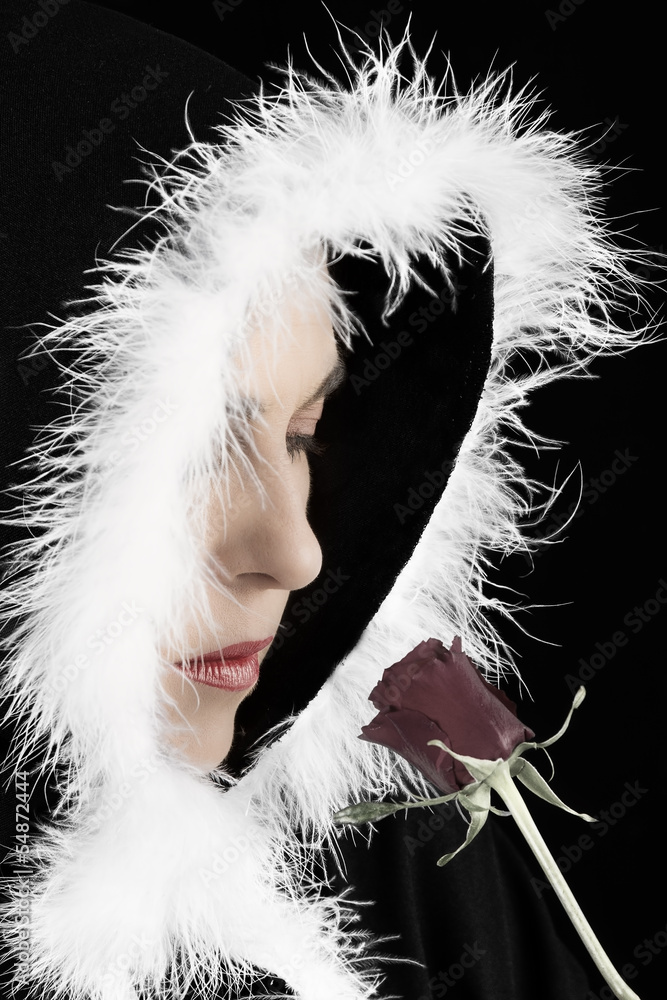 Fototapeta premium Portrait of sad woman in black cape and rose artistic conversion