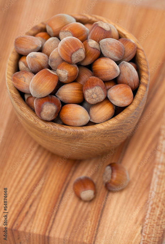 hazelnuts in a wooden bowl on wooden table hazelnuts in a wooden bowl on wooden table
