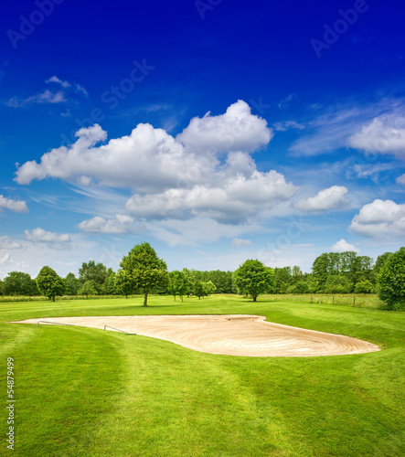 green golf course and dramatic blue sky