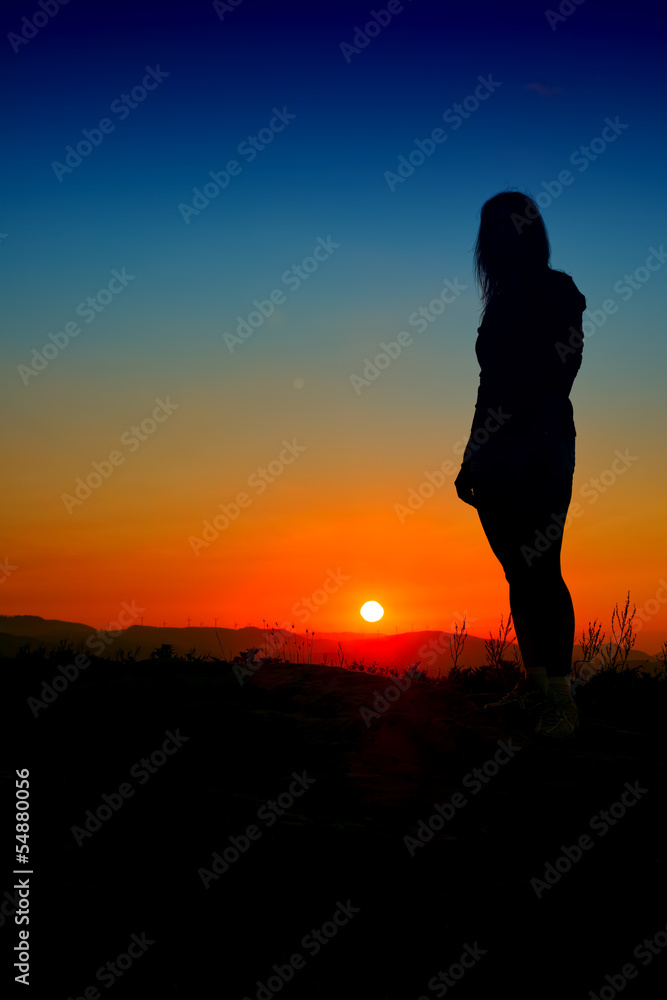 girl silhouette at sunset with blue sky