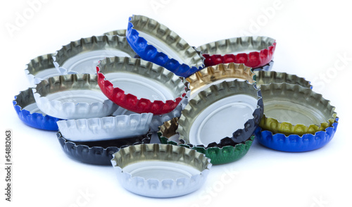 A stack of metal bottle caps isolated on white background.