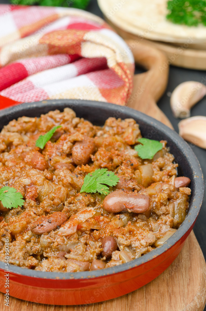 chili con carne in a cast iron skillet vertical closeup chili con carne in a cast iron skillet vertical closeup
